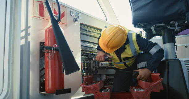 A worker in a hard hat and safety vest is diligently working on a train in an infrastructure pipeline project.